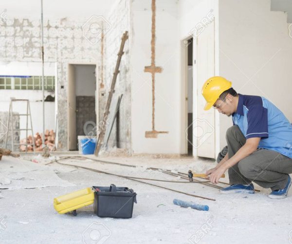 Construction worker with hardhat working at site, house renovation.